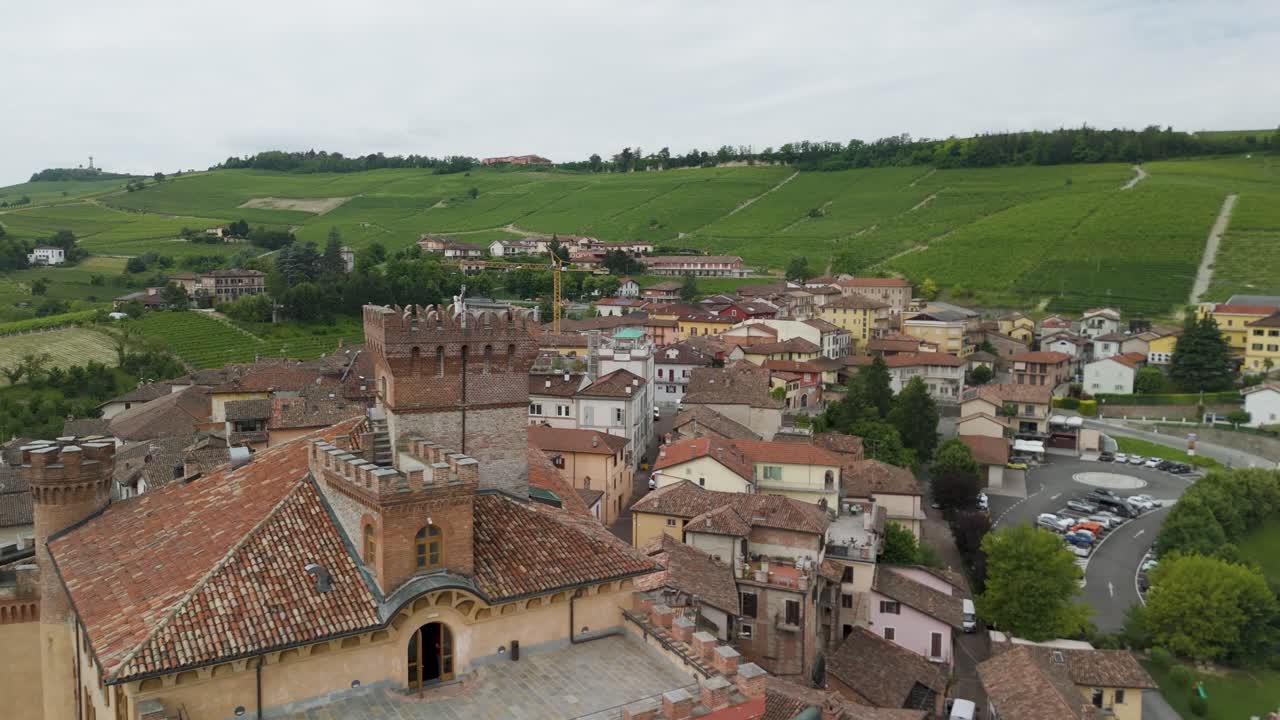 Barolo Castle in Langhe Wine Region, Cuneo, Piedmont, Italy. 4K Aerial view of the village and the vineyards, flying forward close to the castle on the left.