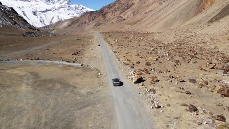 Drone-Siguiendo-Un-Coche-Todoterreno-En-El-Valle-De-Spiti,-Montaña-De-Arena-De-Himachal-Pradesh