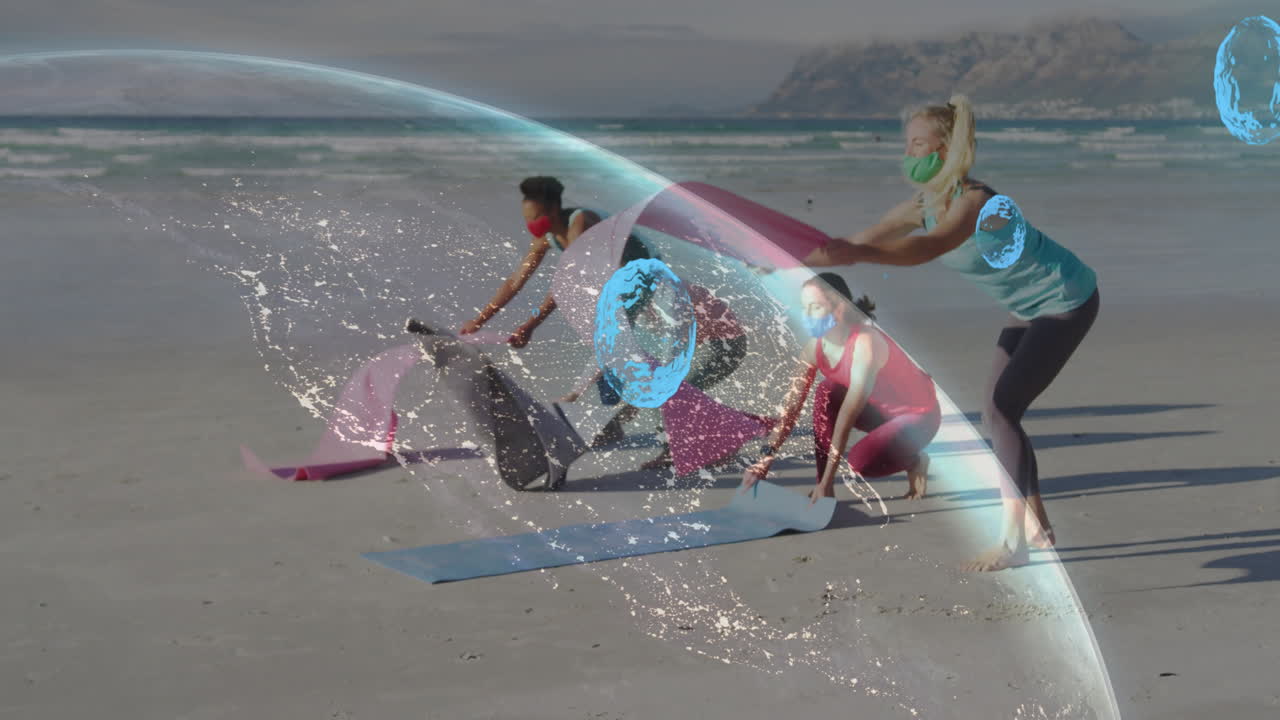 People setting up yoga mats on beach with digital network animation overlay