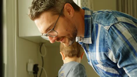 padre y hermanos limpiando el fregadero de la cocina 4k