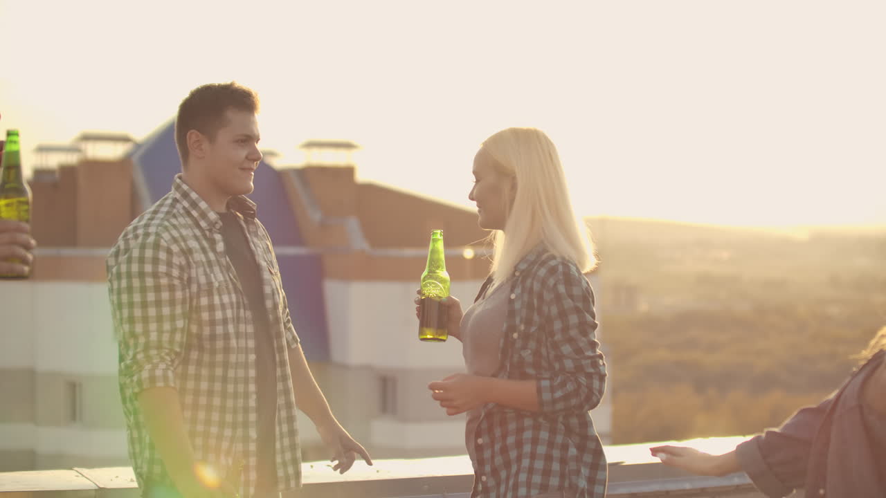 un amoroso matrimonio está bailando en el techo con sus amigos en una fiesta. disfrutan de la mirada del otro.