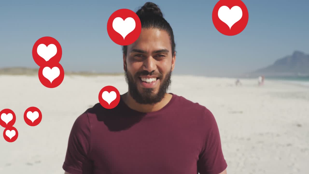 Animação de ícones de coração vermelho de amor de redes sociais sobre homem sorridente na praia