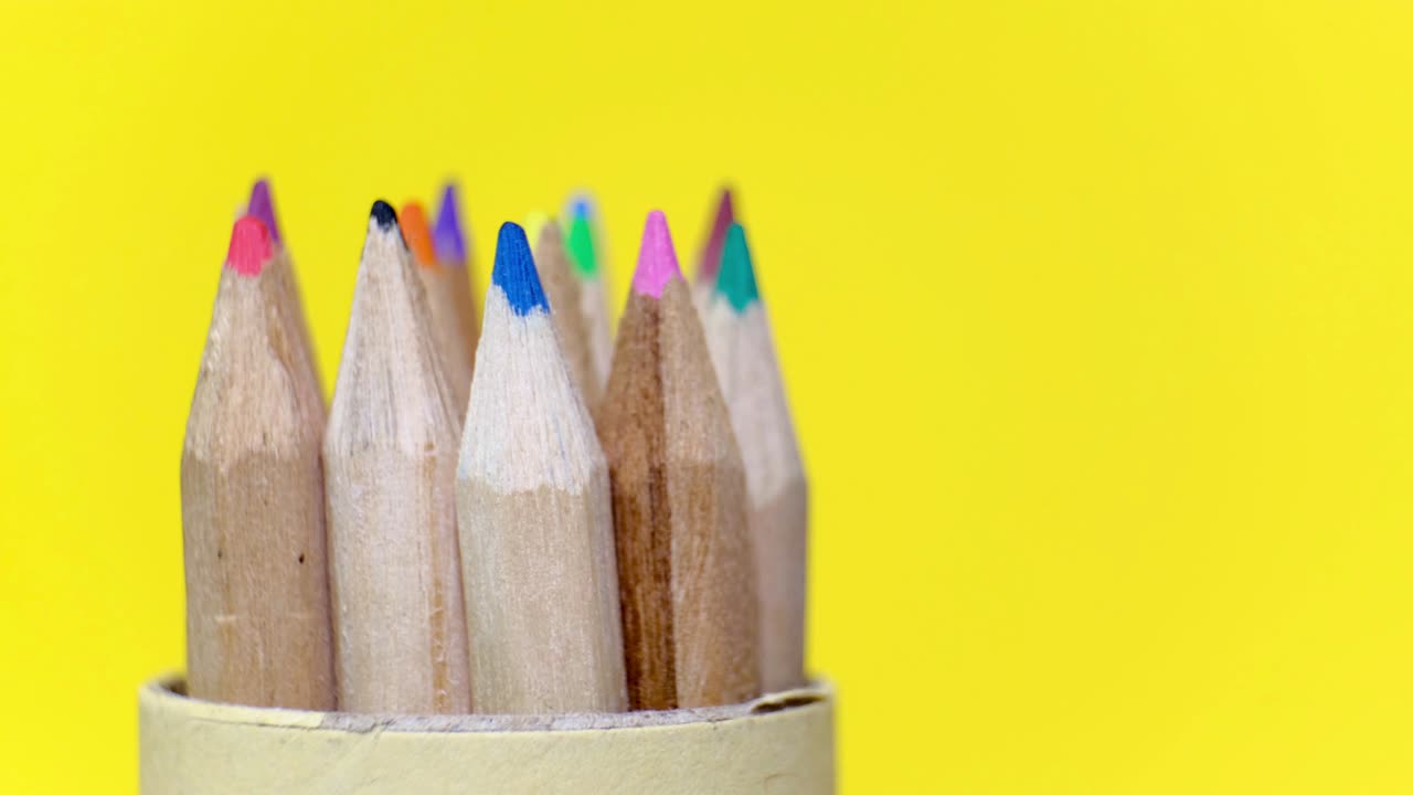 노란색 배경에 회전하는 다양한 색상의 목조 연필의 클로즈업 세트. 복사 공간과 함께 고립된 객체.