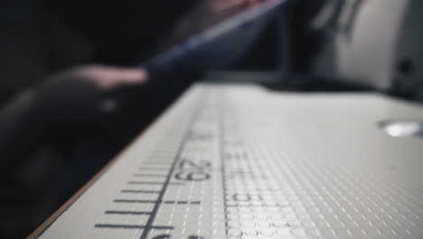 table with measure scale and seamstress near sewing machine