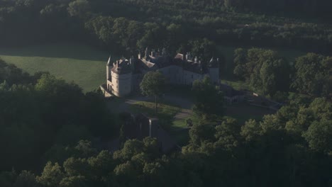 Reveal-shot-of-Walzin-castle-in-green-nature-during-sunrise,-aerial