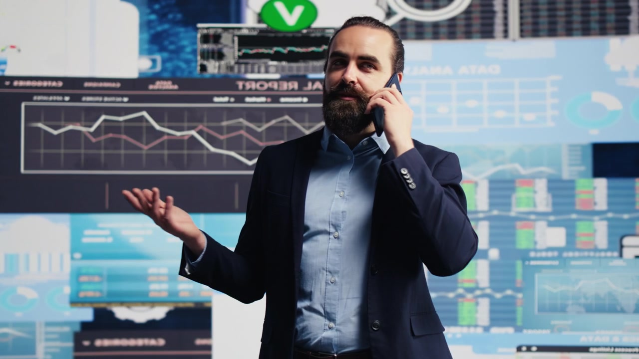 Uomo d'affari esamina le analisi finanziarie mentre parla al telefono