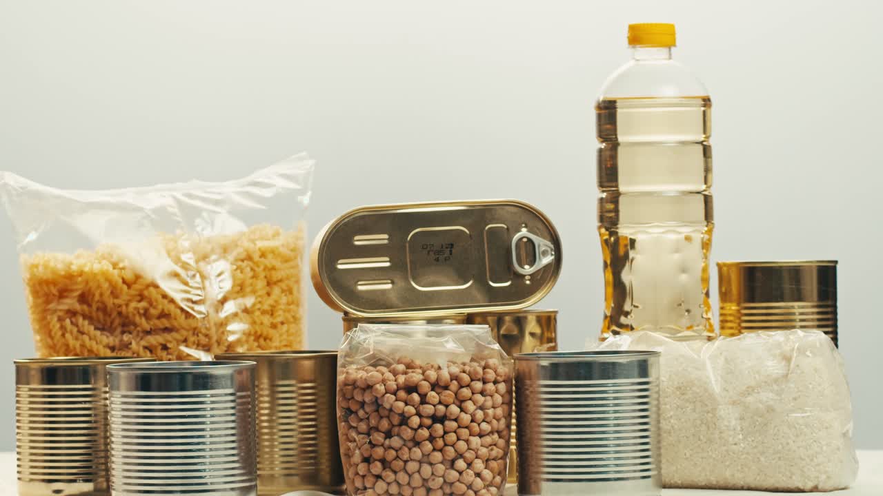 Canned cereals beans fish and vegetables, an assortment of processed foods, supermarket cart online shopping, delivery.