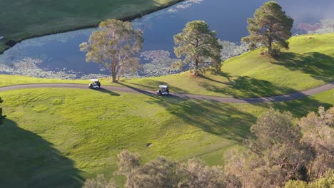 golf carts traverse a scenic course at sunset, surrounded by lush greenery and tranquil water, creating a serene atmosphere