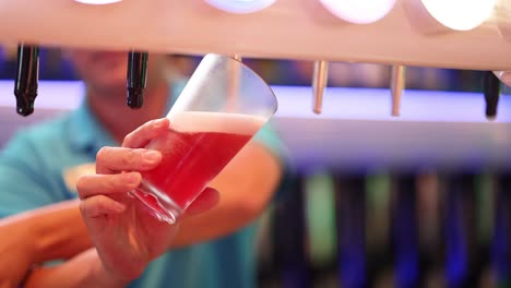 bartender pouring red beer into glass