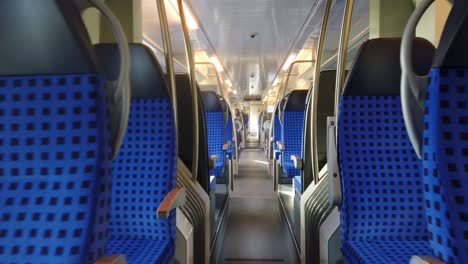 walking through an moving empty german train with blue seats