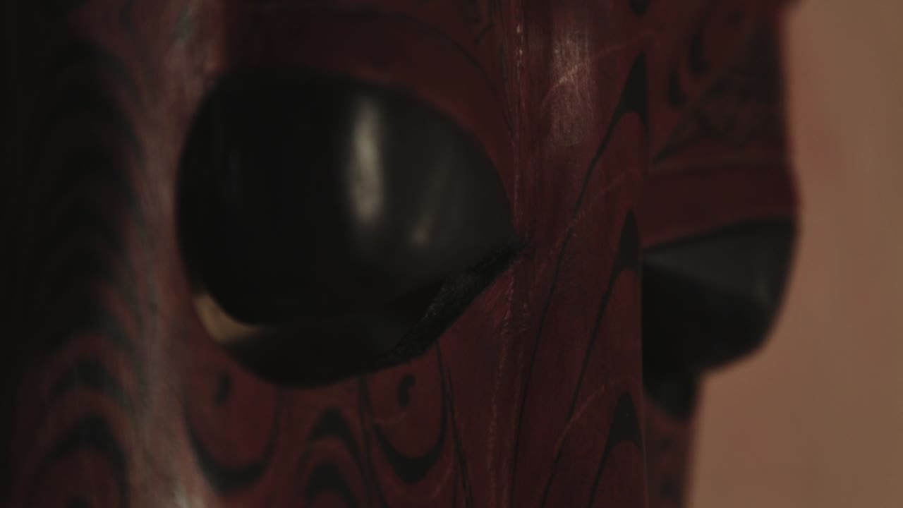 una decoración de máscara de cabeza humana tribal de madera única en la pared - primer plano