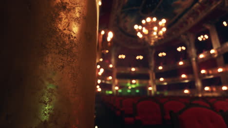 empty theater seats with chandelier and golden column