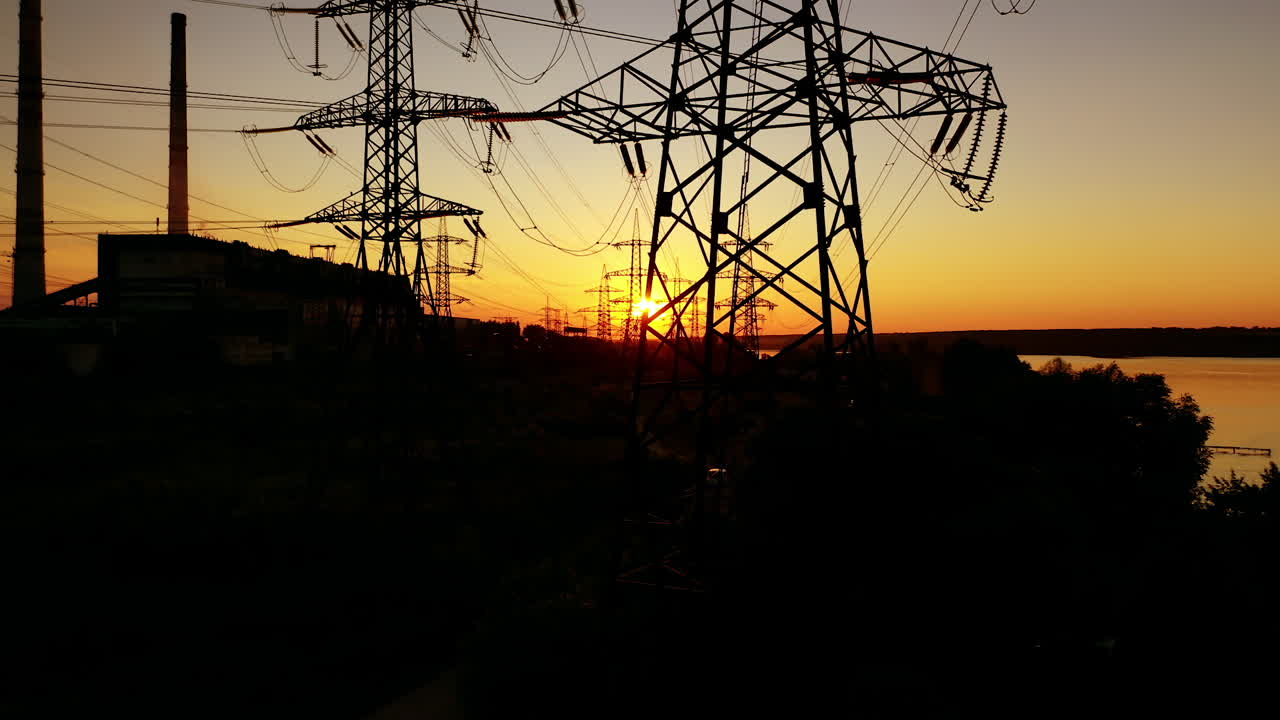 Power lines on colorful sunset. Electric post with wires with sunset background