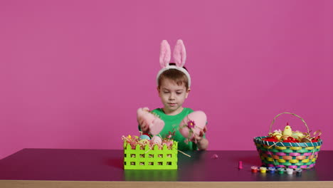 pequeño niño satisfecho presentando adornos hechos a mano ocultos