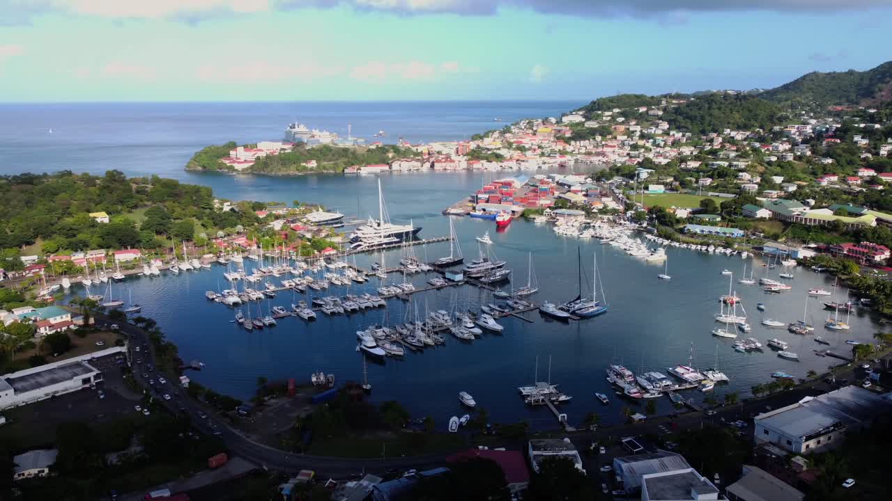 Aerial pan of half shadow seaside town with harbor yachts