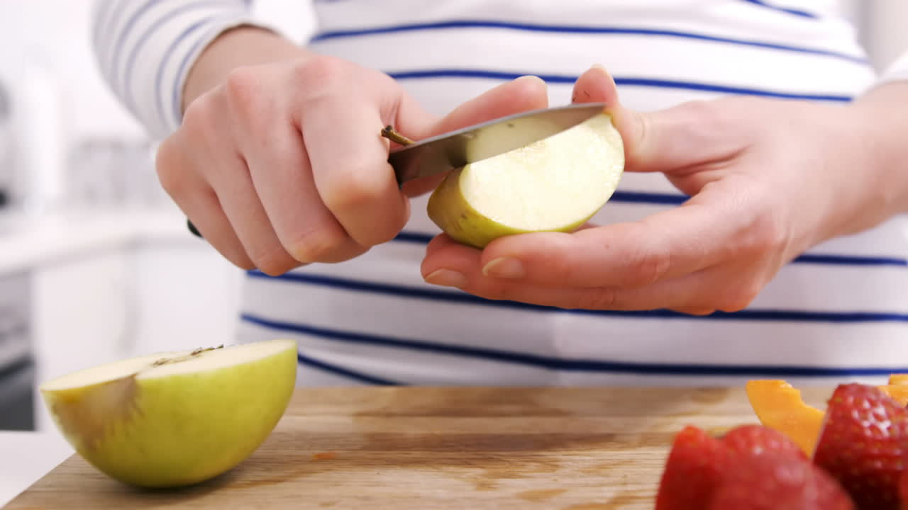 Primo piano di una donna che intaglia frutta