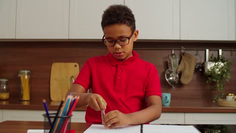 un niño afroamericano de edad escolar lindo dibujando un círculo con una brújula divisora