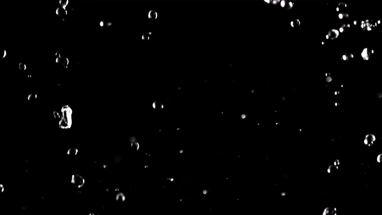 Goccioline d'acqua che cadono contro uno sfondo nero
