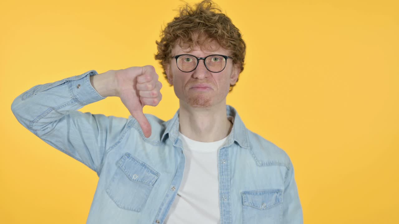 엄지손가락을 내려놓은 은 머리 젊은이, 노란색 배경