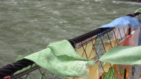 farbige gebetsfahnen auf der tibetischen brücke über den fluss in der nähe des dorfes sichuan in china schwenken