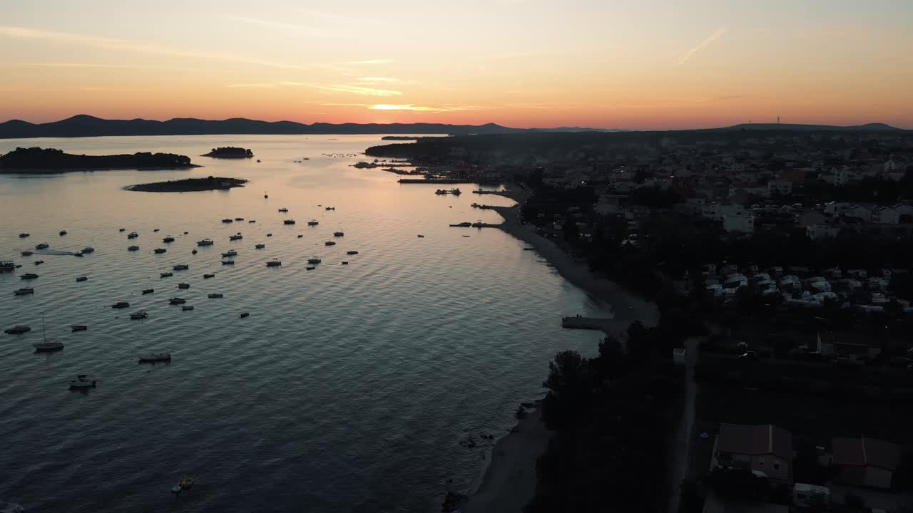 paisaje panorámico con barcos en marina bay, mar, luces de la ciudad, montañas, cielo azul al atardecer