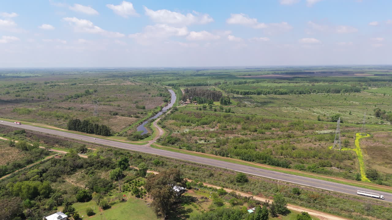 Expansive aerial view of grassy plains and intersecting roads through rural countryside at Paraná Delta, Argentina.
