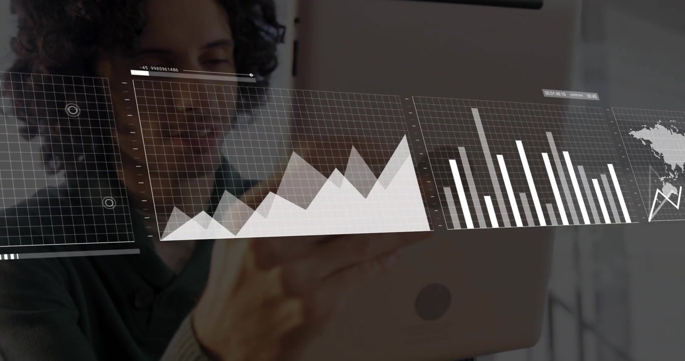 Man tilting tablet, showing floating line graph bar chart and world map overlays for finance review