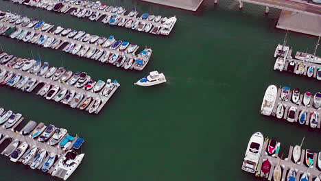 drone footage of a boat pulling up to the dock, in a harbor