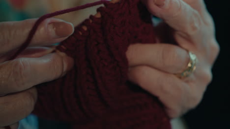 close up of senior female old skilled hands working on crochet