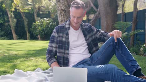 man using laptop in the garden 4k