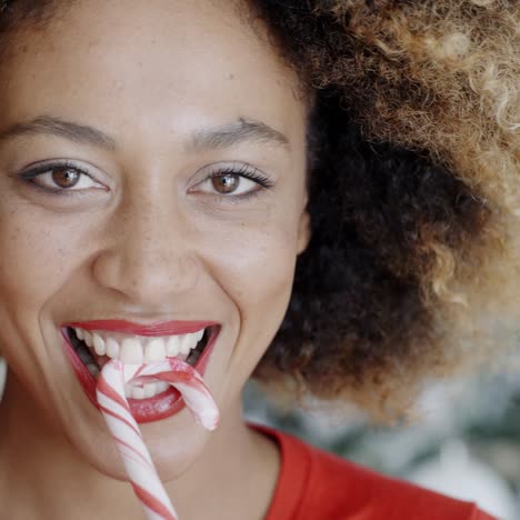 Fun-young-woman-biting-Christmas-candy-cane