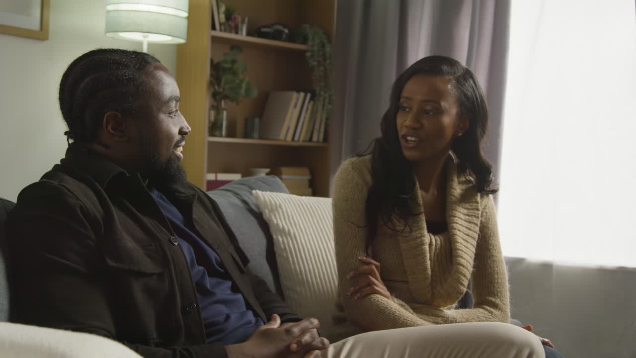 Couple At Home Sitting On Sofa In Lounge Having Breaking Up Argument 8