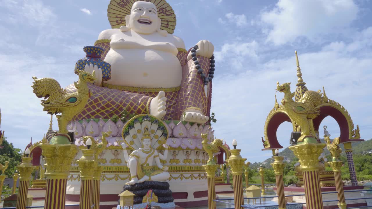 cámara alejándose de la estatua de buda en el templo wat plai laem en koh samui, tomada desde un ángulo bajo