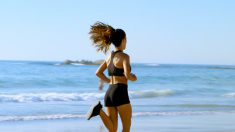 Fit-woman-jogging-in-the-beach-4k