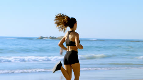 fit woman jogging in the beach 4k