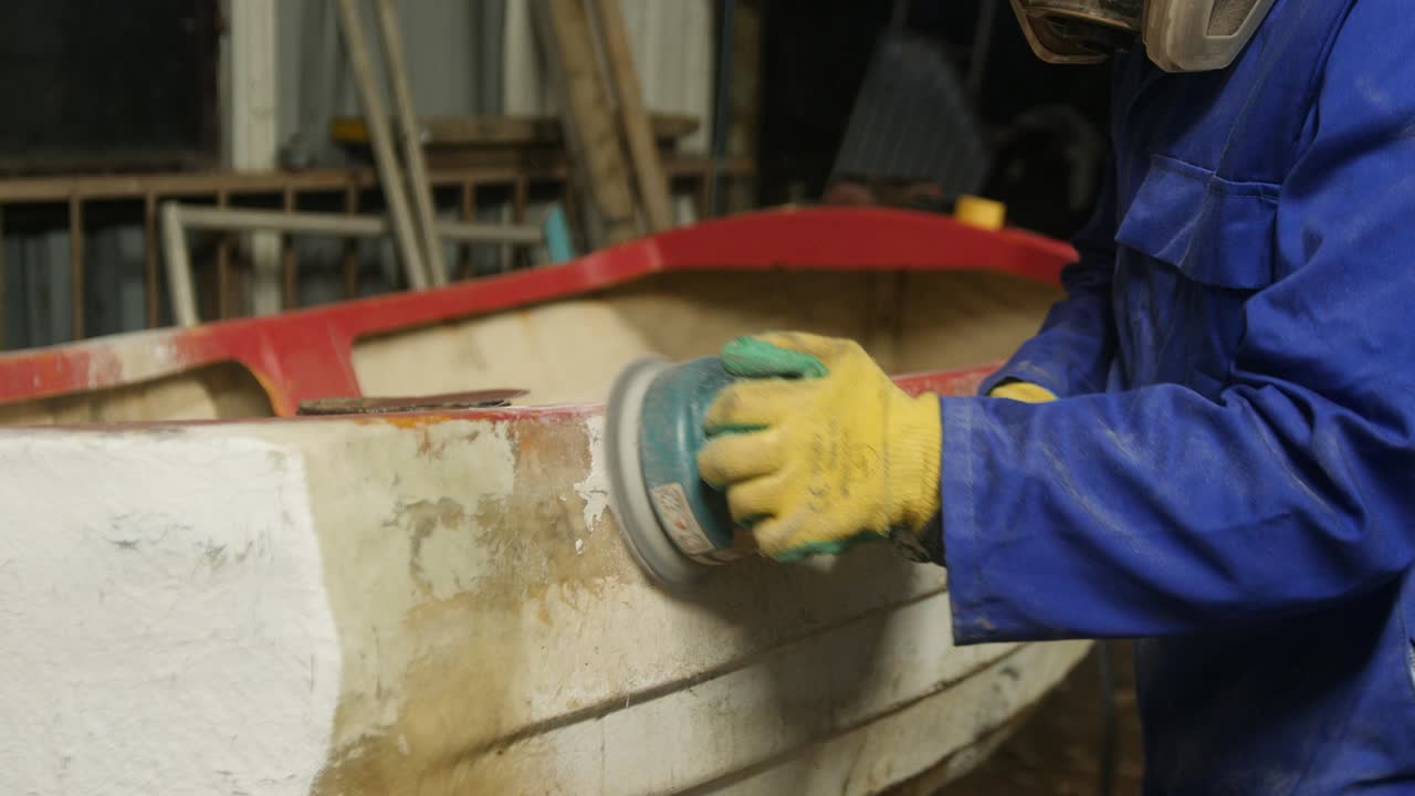 Sanding fiberglass boat hull using orbital sander