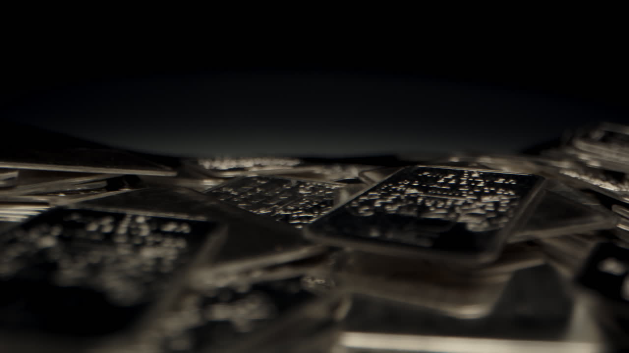 Stunning cinematic dolly of shiny silver plates lying on black fabric in a dark room