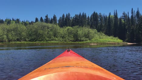 A-static-shot-of-the-bow-of-a-kayak-drifting-across-a-river