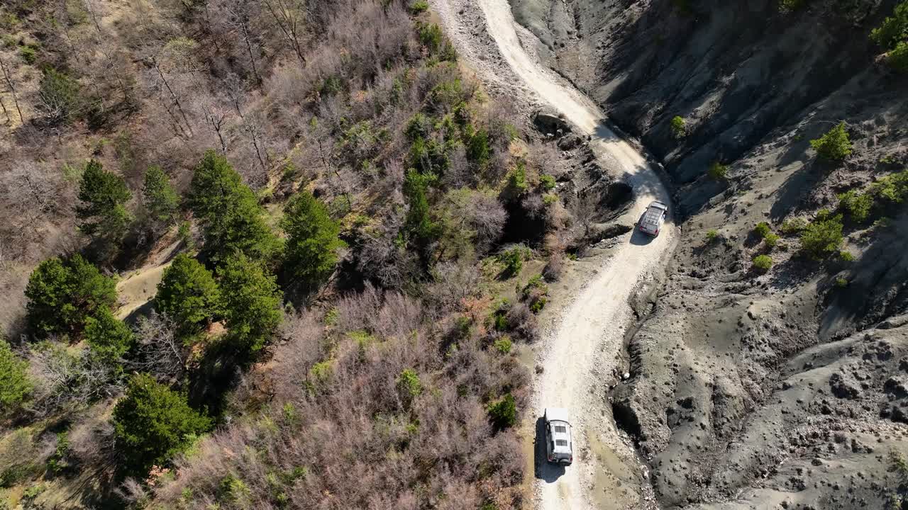 두 대의 오프 로드 자동차가 언덕의  ⁇ 길을 달리고 있다