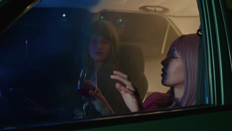 two women in a car at night