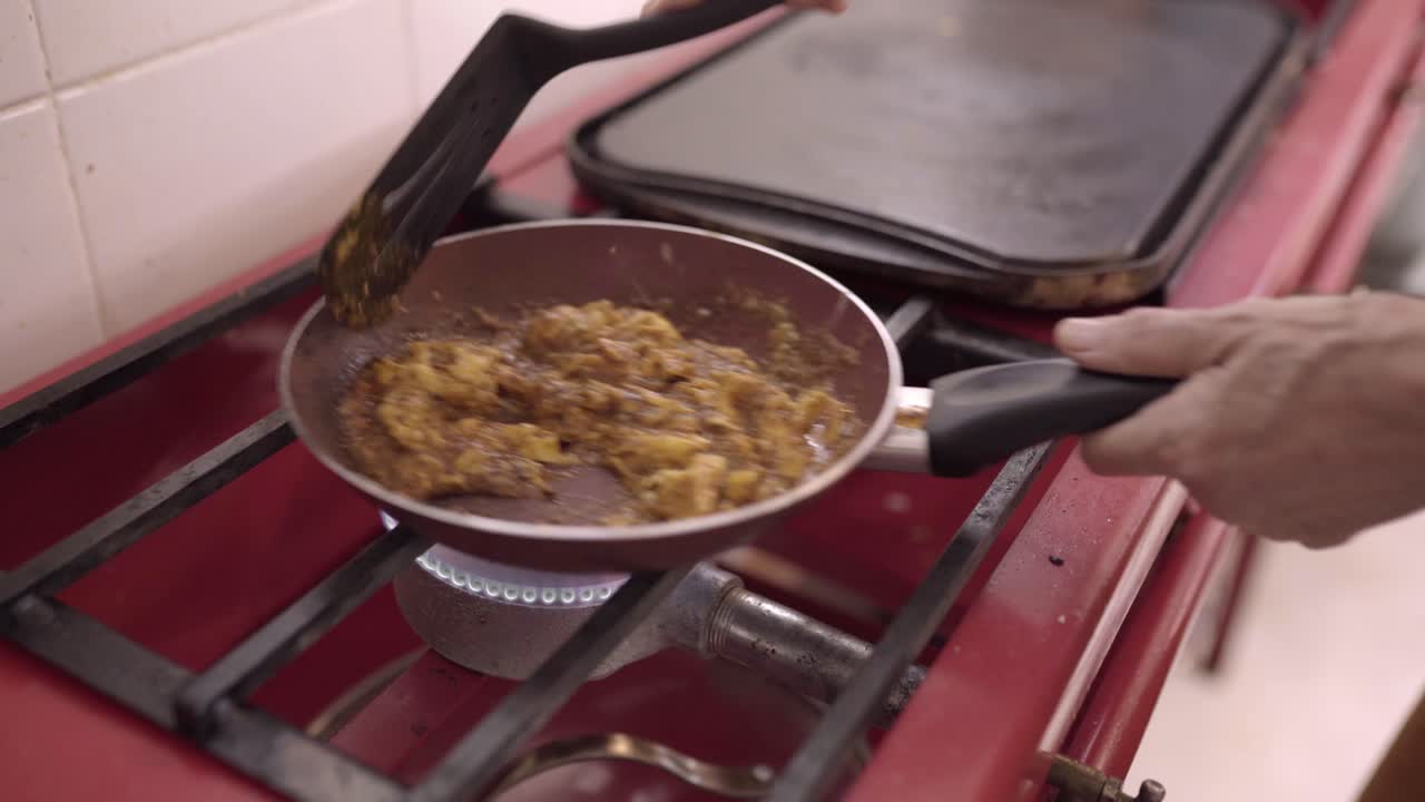 cocinero sin rostro fritando huevos con salsa