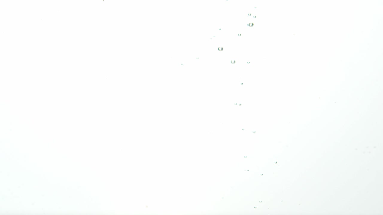 bayas rojas frescas caídas en el agua con burbujas en aumento, aisladas en blanco