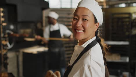 Animation-of-happy-asian-female-baker-holding-basket-with-baguettes