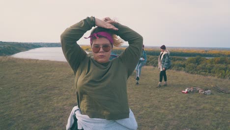 chica con sobrepeso arregla el cabello por amigos en el campamento en green bank
