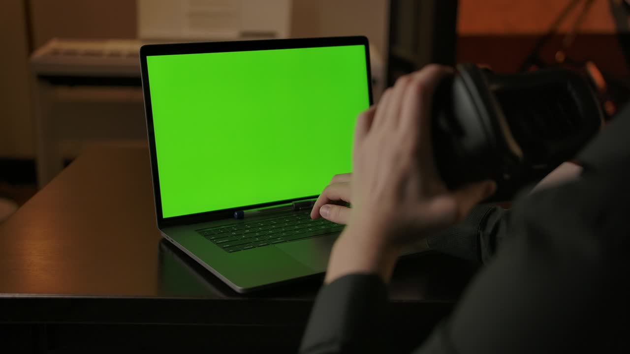 ingeniero caucásico con casco vr escribiendo en una computadora portátil con pantalla verde