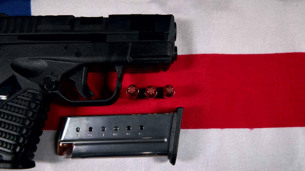 black Semi-Automatic 9mm Handgun on American flag with Loaded Magazine and Bullets,  right hand side view, slow pan right to left, 4k