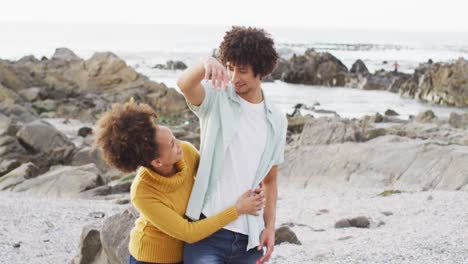 Porträt-Eines-Afroamerikanischen-Paares,-Das-Sich-Auf-Den-Felsen-Am-Meer-Umarmt