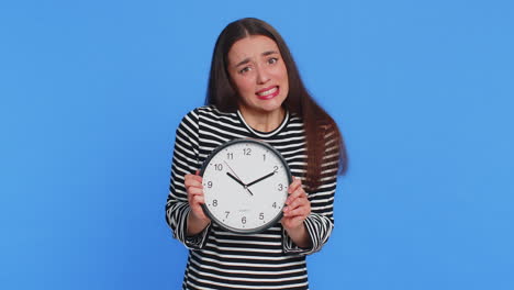 caucasian woman with anxiety checking time on clock running late to work being in delay deadline