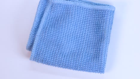 blue dishcloth rotating over white surface