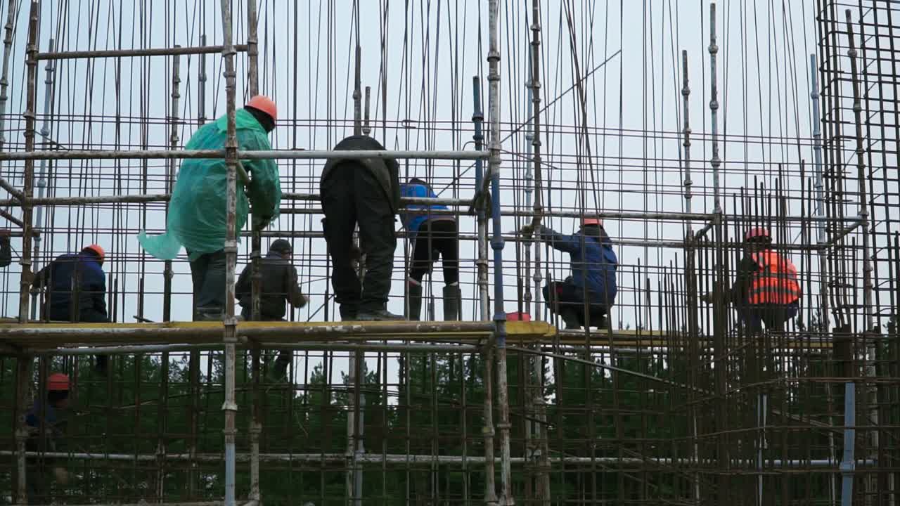 建設 場 の 足場 に 作業 する 作業 者 たち